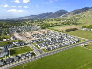 Aerial view of property and surrounding area featuring nearby suburban area and a mountainous background
