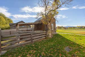 View of property exterior with a metal roof, a mountain view, a lawn, and an outbuilding