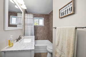 Full bathroom with vanity, shower / bath combination with curtain, and tile patterned flooring