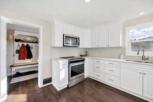 Kitchen featuring white cabinetry, stainless steel appliances, dark wood-style floors, decorative backsplash, and recessed lighting