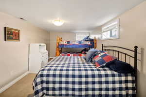 Bedroom featuring baseboards and light carpet