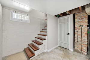 Basement with stairs and brick wall