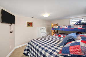 Bedroom with baseboards and light carpet
