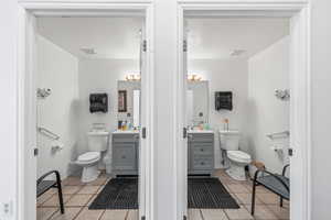Half bath with vanity and light tile patterned floors