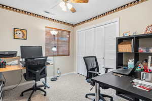 Home office featuring light carpet and a ceiling fan