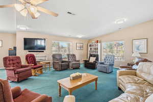 Living area featuring carpet, healthy amount of natural light, a ceiling fan, and lofted ceiling