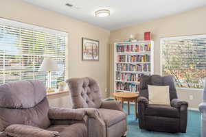 Living area featuring carpet floors and baseboards