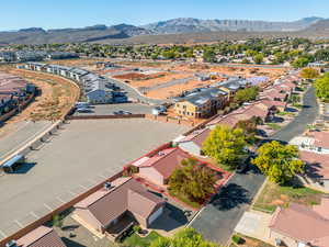 Aerial view of residential area with property boundaries highlighted and a mountain backdrop