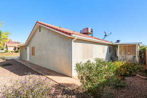 View of property exterior with stucco siding and a tiled roof