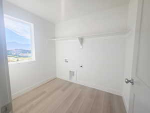 Laundry room with light wood-type flooring, electric dryer hookup, and washer hookup