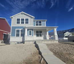 View of front of house featuring covered porch, stone siding, board and batten siding, and a mountain view