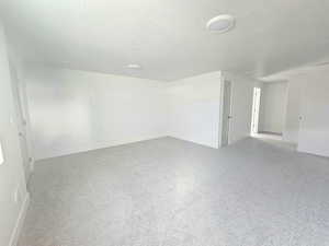 Unfurnished room featuring a textured ceiling and baseboards