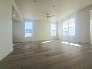 Empty room with plenty of natural light, recessed lighting, ceiling fan, and dark wood-type flooring