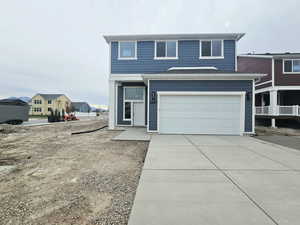 Traditional-style home featuring concrete driveway and an attached garage