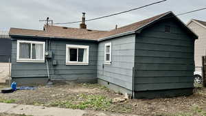 View of side of property featuring a chimney and a shingled roof