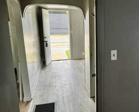 Entryway with arched walkways and wood finished floors