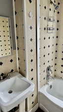 Full bathroom featuring tile walls and shower / bath combination
