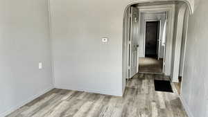 Hall featuring wood finished floors and arched walkways