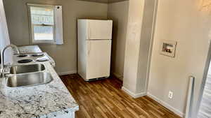 Kitchen featuring freestanding refrigerator, light countertops, range with electric cooktop, and wood finished floors