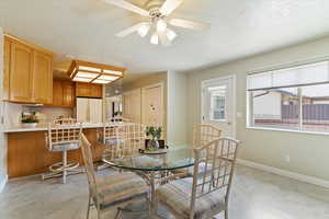 Dining area with a textured ceiling and a ceiling fan