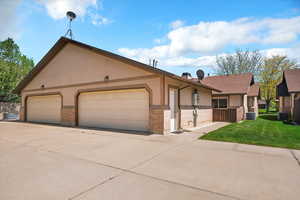 View of front of home with brick siding, concrete driveway, and stucco siding