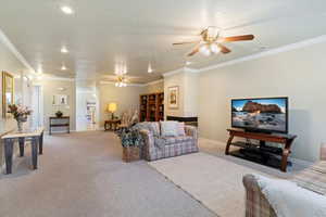 Carpeted living room featuring ornamental molding, a ceiling fan, a textured ceiling, and recessed lighting