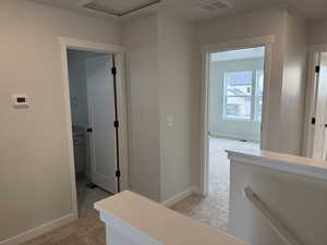 Corridor with light carpet and an upstairs landing