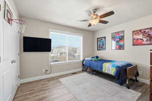 Bedroom with ceiling fan and light wood-style floors