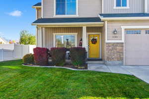 Property entrance with a porch, a garage, board and batten siding, and roof with shingles