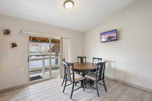 Dining room with wood finish floors and lofted ceiling