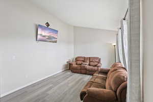 Living room featuring wood finished floors and lofted ceiling
