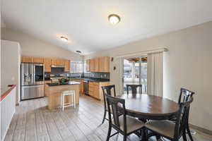 Dining space with vaulted ceiling and wood finish floors