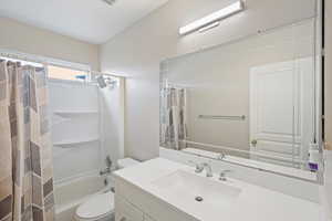Full bath with shower / bath combination with curtain and vanity