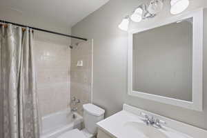 Bathroom featuring vanity and shower / bathtub combination with curtain