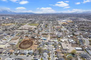 Aerial view of property and surrounding area with nearby suburban area and a mountain backdrop