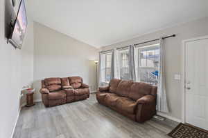 Living area featuring lofted ceiling and light wood-style flooring