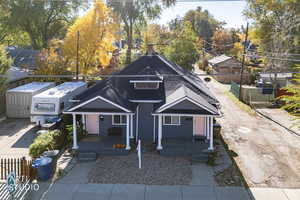View of front facade with covered porch and roof with shingles