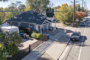 View of front facade with roof with shingles, a porch, and a fenced front yard