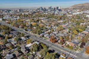 Aerial view of property and surrounding area featuring a mountain backdrop and nearby urban area