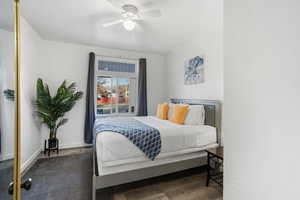 Bedroom featuring wood finished floors, ceiling fan, and a textured wall