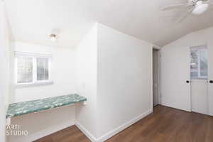 Bonus room with plenty of natural light, dark wood-style flooring, a textured ceiling, vaulted ceiling, and ceiling fan