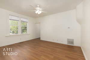 Spare room featuring dark wood-style floors and a ceiling fan