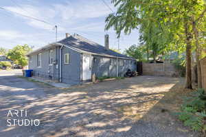 View of side of home with a fenced backyard and a chimney
