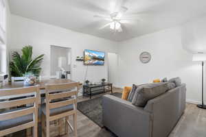 Living room with light wood-type flooring and a ceiling fan