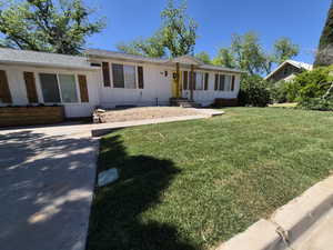 Single story home with board and batten siding and a front lawn