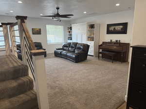 Living area with a textured ceiling, recessed lighting, carpet floors, and ceiling fan