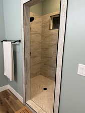 Full bathroom with a stall shower and light wood-style flooring