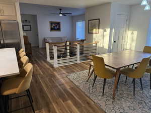 Dining space featuring dark wood finished floors, ceiling fan, and a textured ceiling
