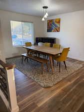 Dining space with a textured ceiling and dark wood finished floors