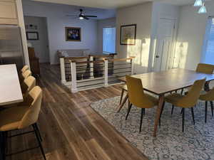 Dining space featuring dark wood-style floors and ceiling fan